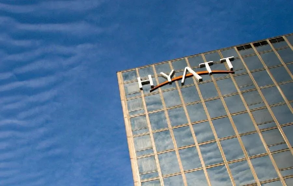 Hyatt hotel tower seen from street level against a blue sky
