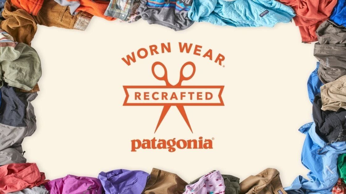 Patagonia Worn Wear Recrafted logo framed by piles of used outdoor clothing, promoting repair and reuse