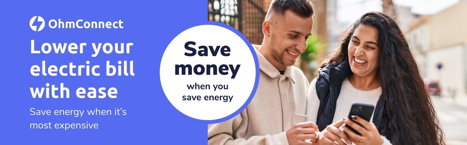 OhmConnect ad showing a couple checking a phone, with the promise to lower electric bills by saving energy
